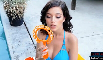 Busty teen beauty shows her round ass and shaved pussy, posing by the swimming pool