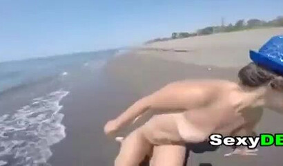 Big bottom teen is sucking a large dick on the beach before her snatch is fucked doggystyle