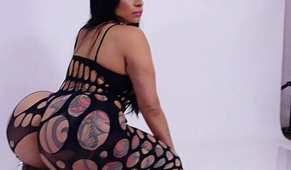 Curvy Latina wearing fishnet bodystocking teasing and shaking her gigantic monster booty
