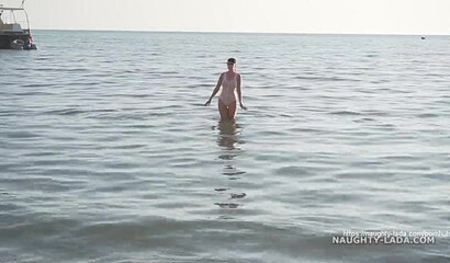 Naughty MILF walking in public in transparent bikini and shows her big tits